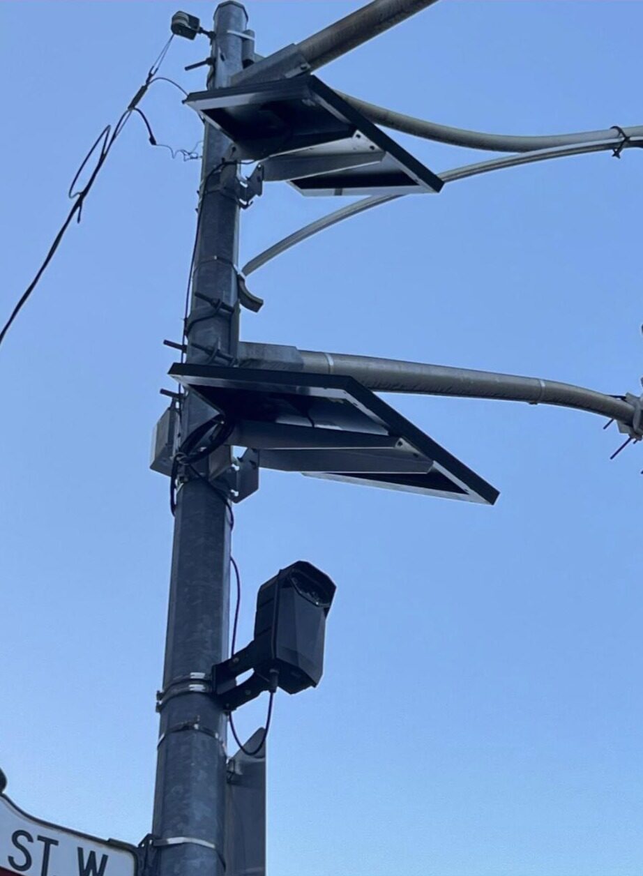 South-facing Genetec AutoVu Cloudrunner — a fixed, solar-powered ALPR — on a City traffic pole at the NW corner of Bloor St W & Spadina Ave. The angled solar panels and antenna make it a self-contained, quick-deploy unit that draws none of the pole's power or data.